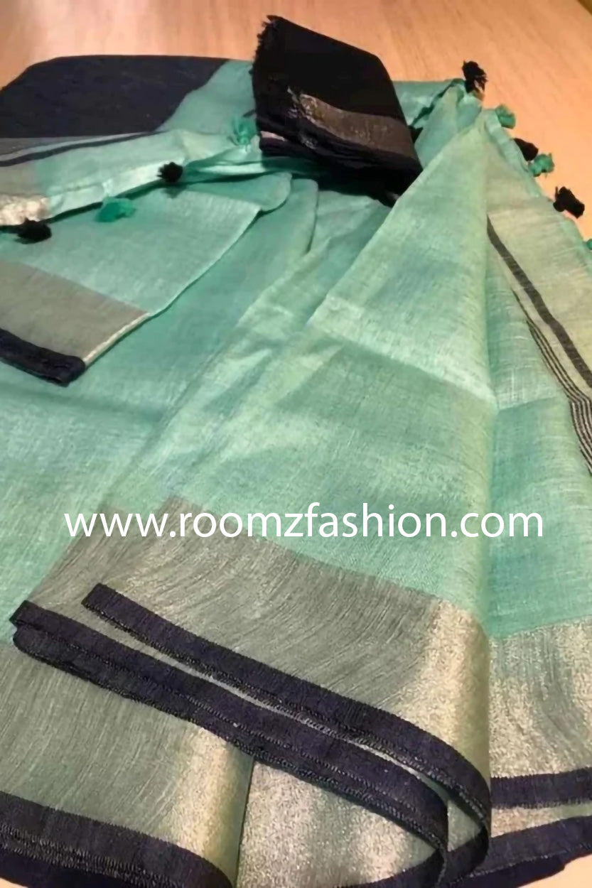 Turquoise linen saree with silver border and black piping draped elegantly
