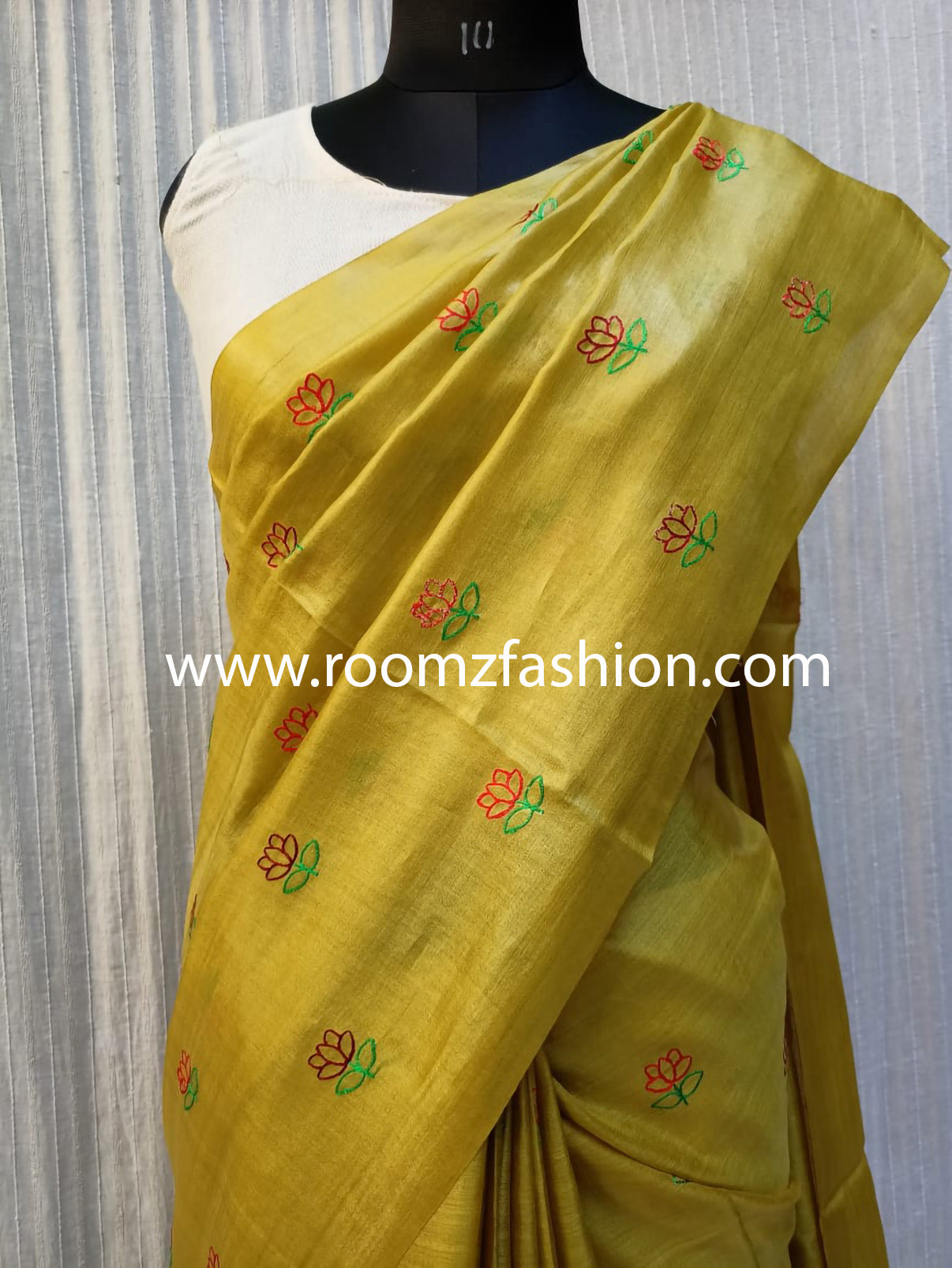 Hand-stitched floral embroidery detail on yellow saree