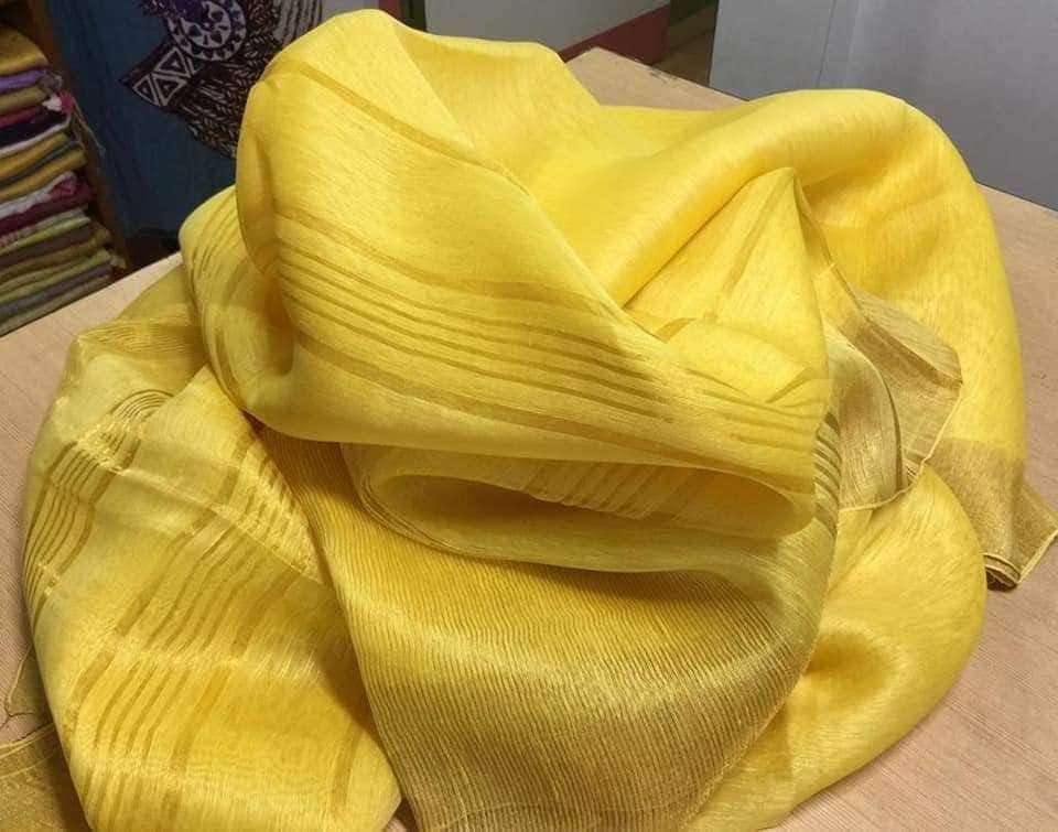 Yellow silk linen saree with golden zari border draped elegantly