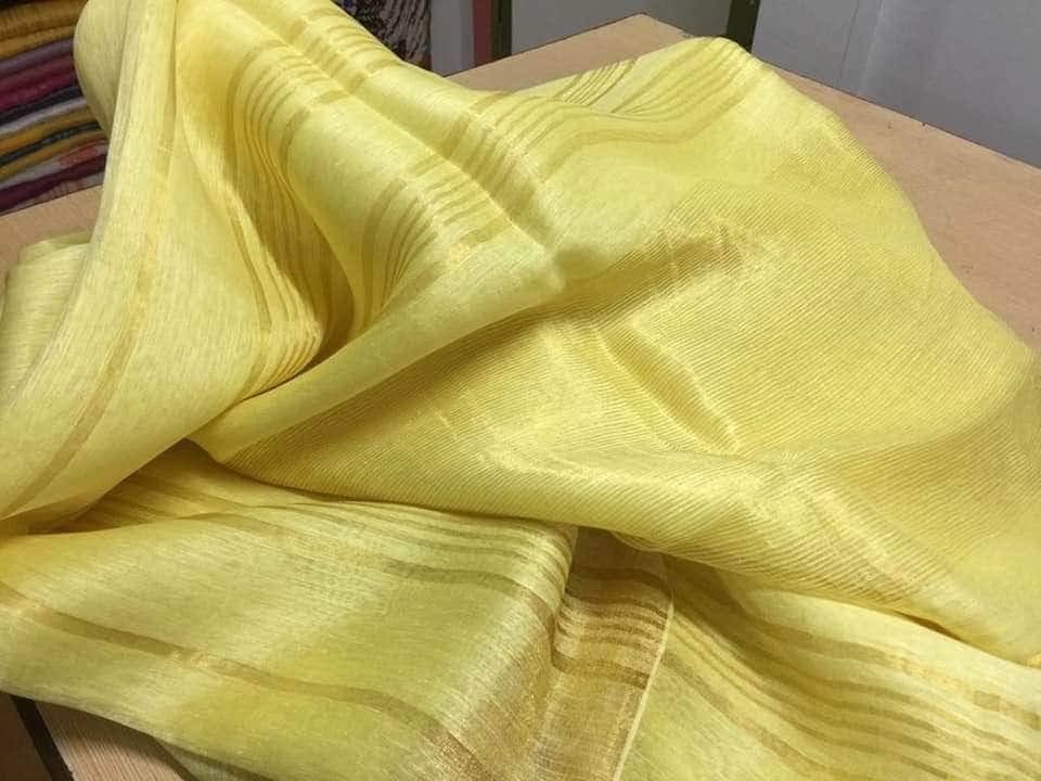 Yellow silk linen saree with golden zari border draped elegantly