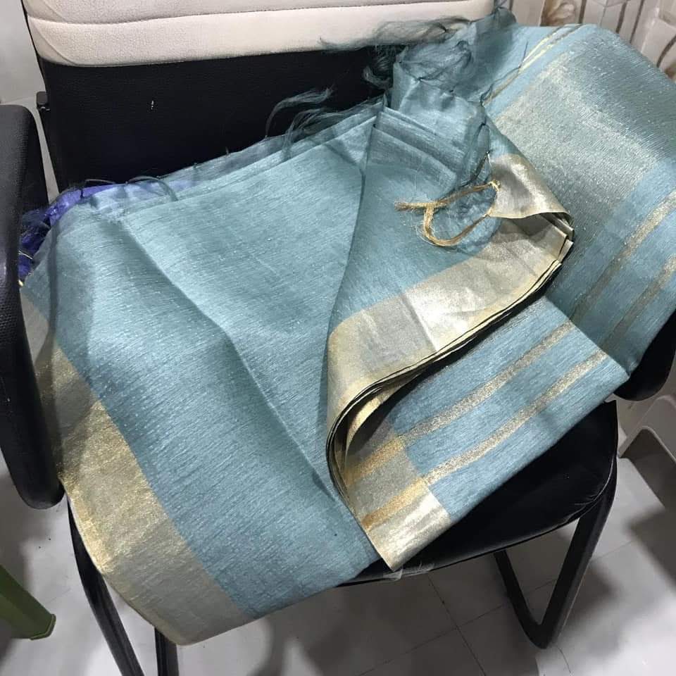 Elegant turquoise blue silk linen saree with golden zari border draped on model