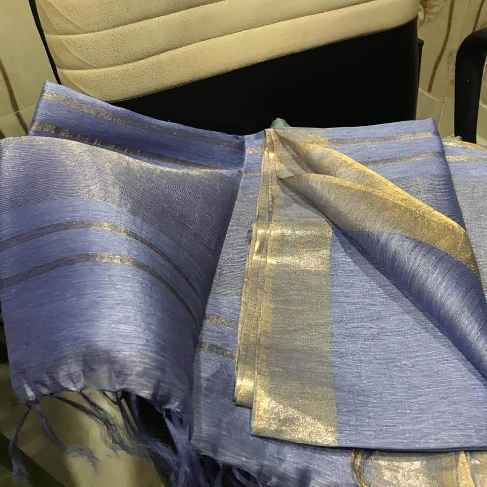 Bluish gray silk linen saree with golden zari border draped elegantly