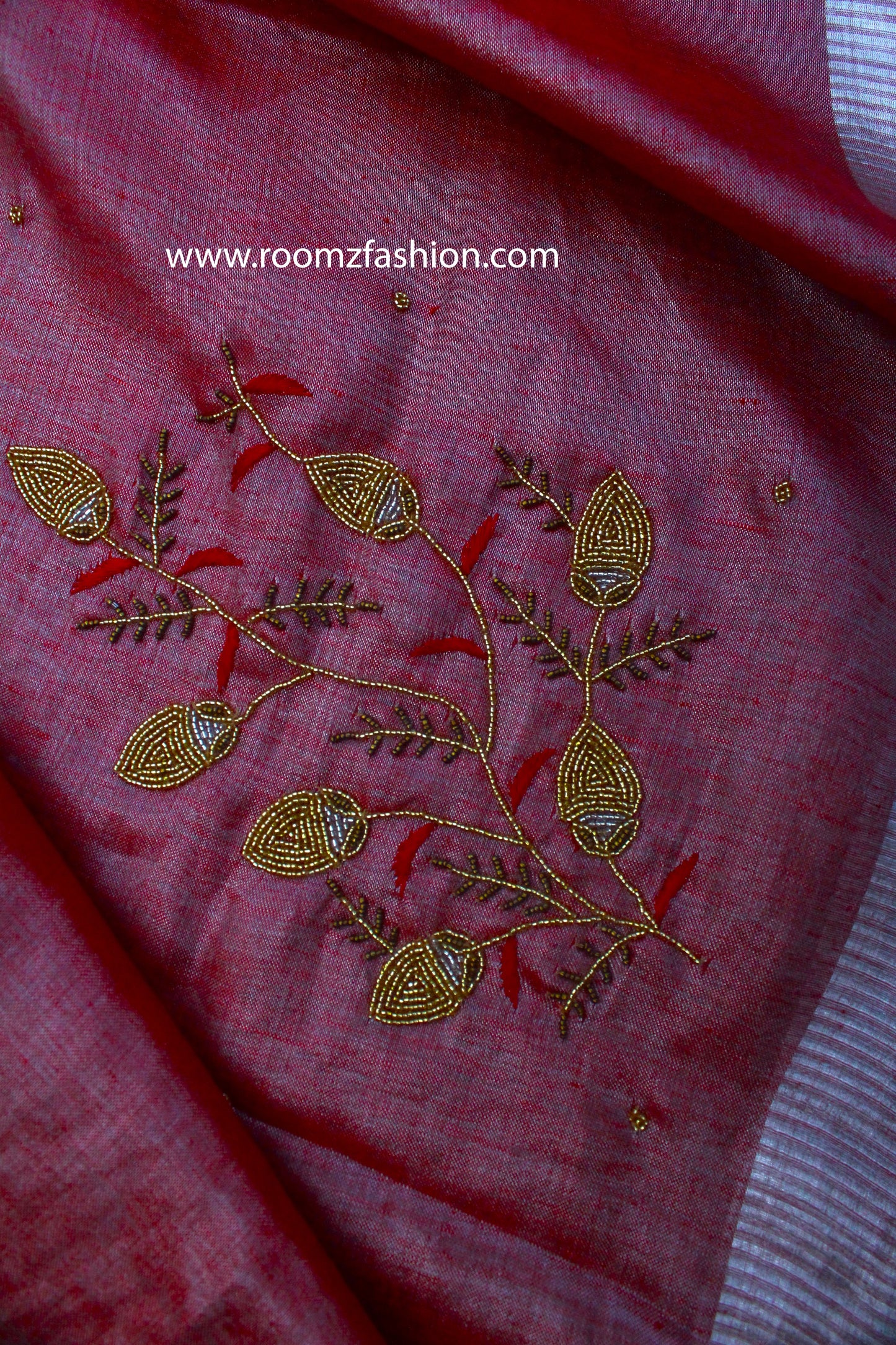 Close-up of silver zari border on orange saree - Roomz