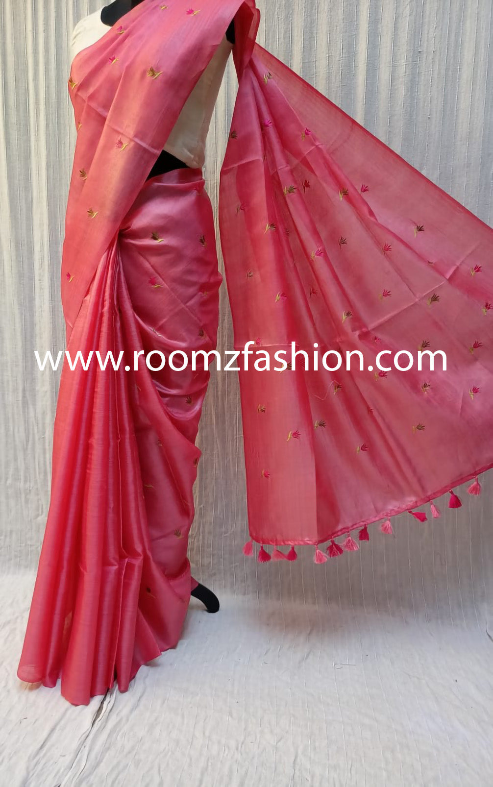 Hand-stitched floral embroidery detail on orange saree