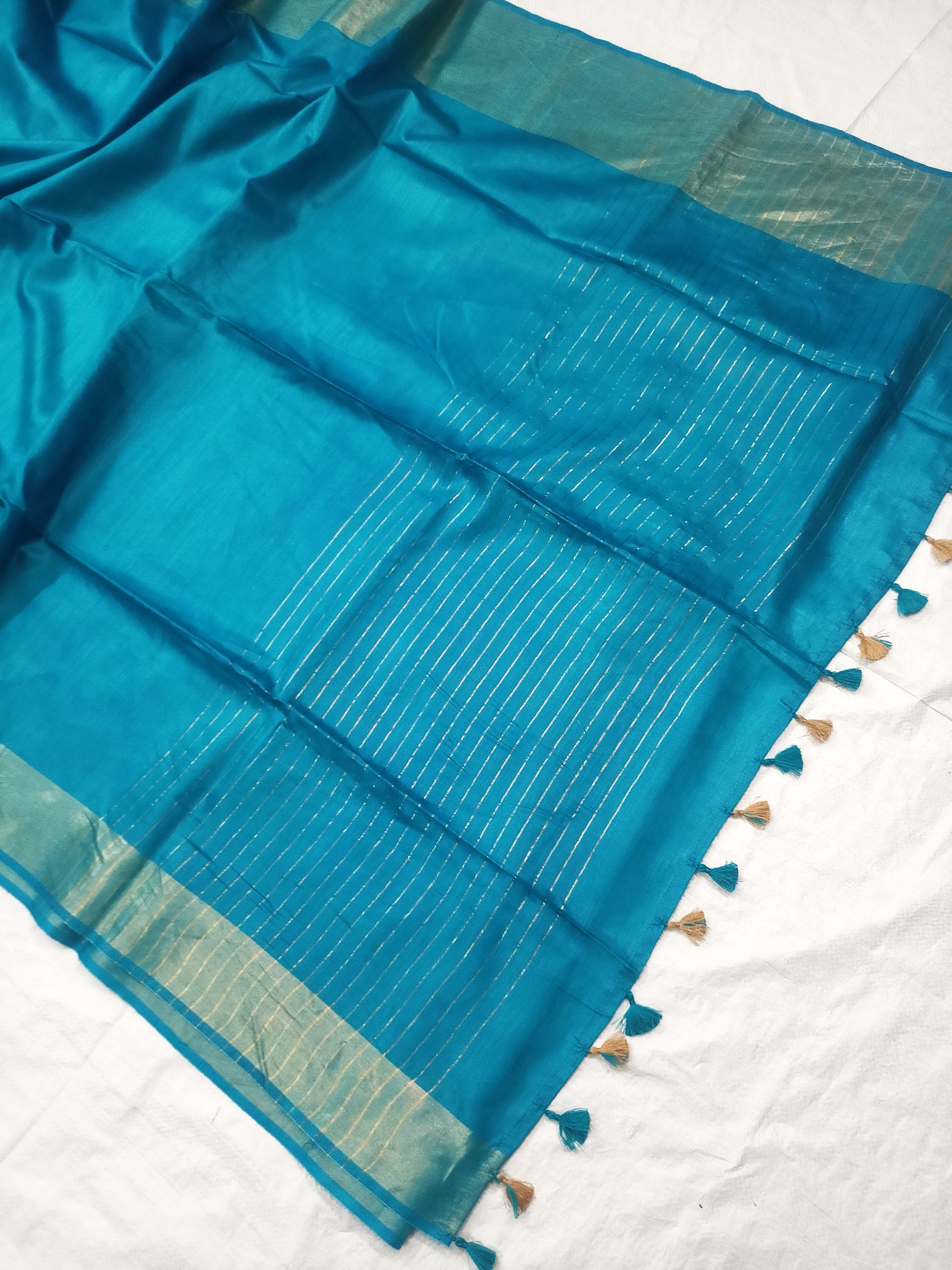 Draped turquoise silk saree showing elegant fall and color