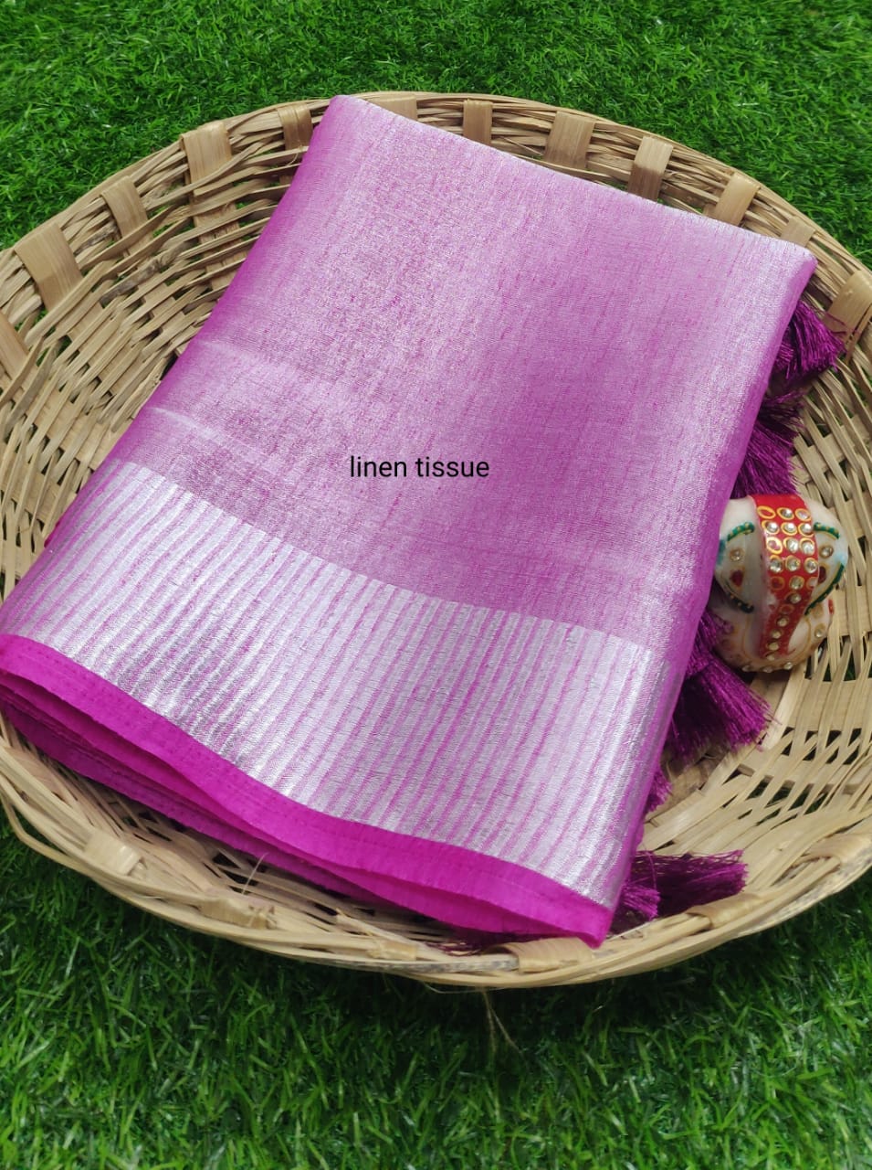 Purple tissue linen saree with golden zari border draped elegantly