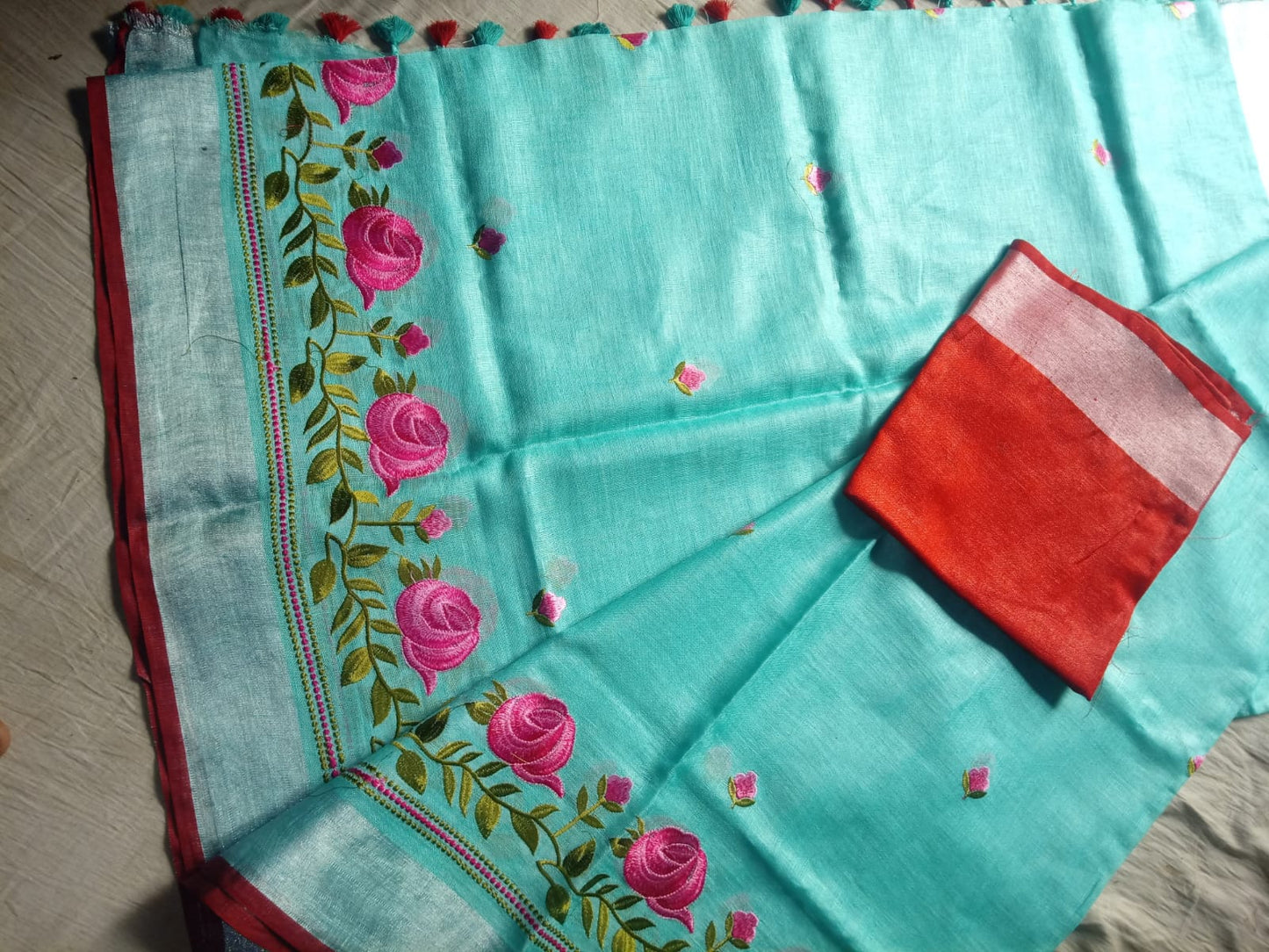 Floral embroidery detail on pastel green saree