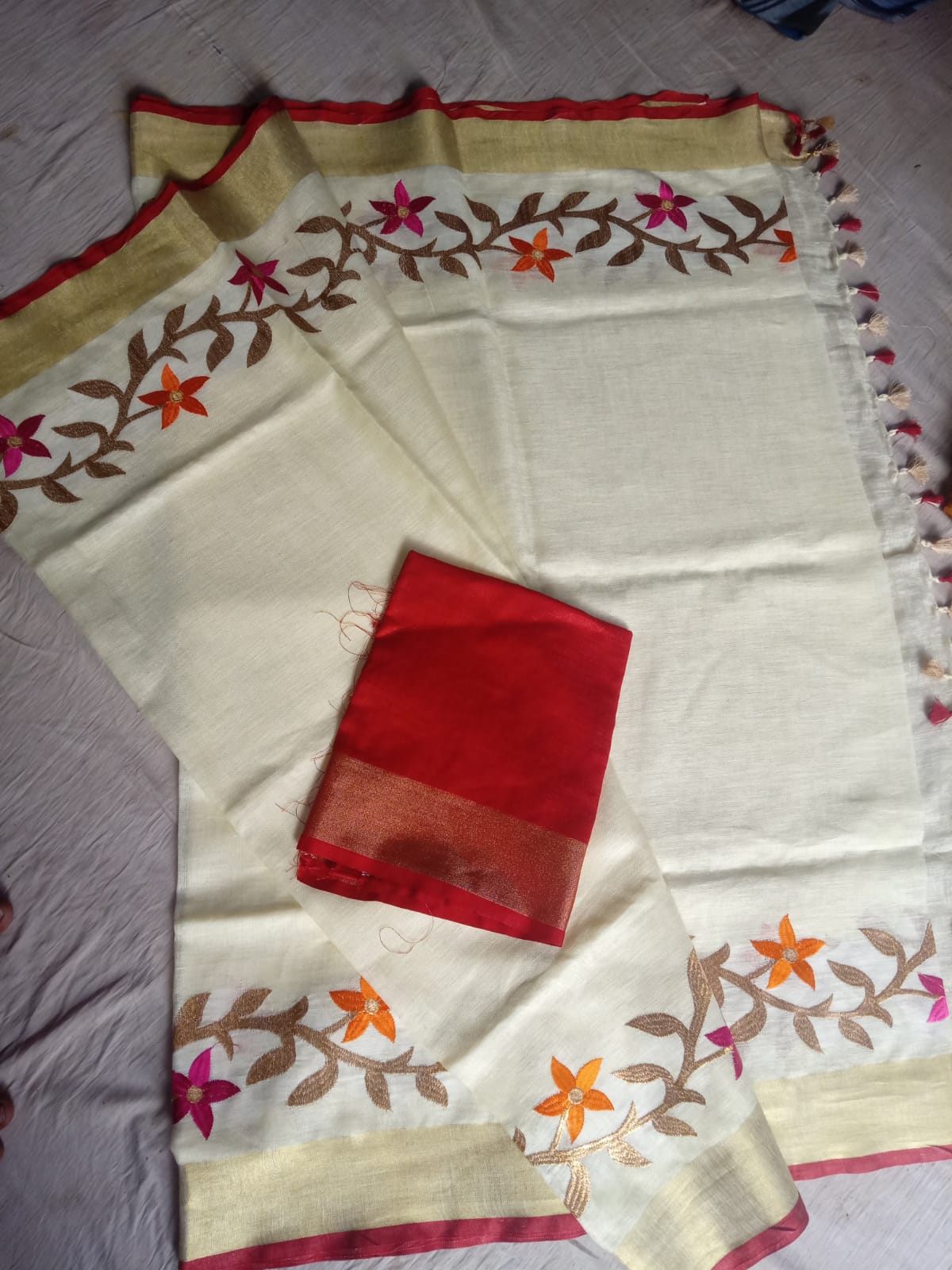 Floral embroidery detail on off-white saree
