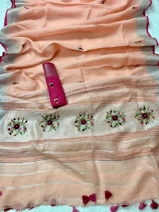 Peach linen saree with silver-zari border and hand embroidery draped elegantly