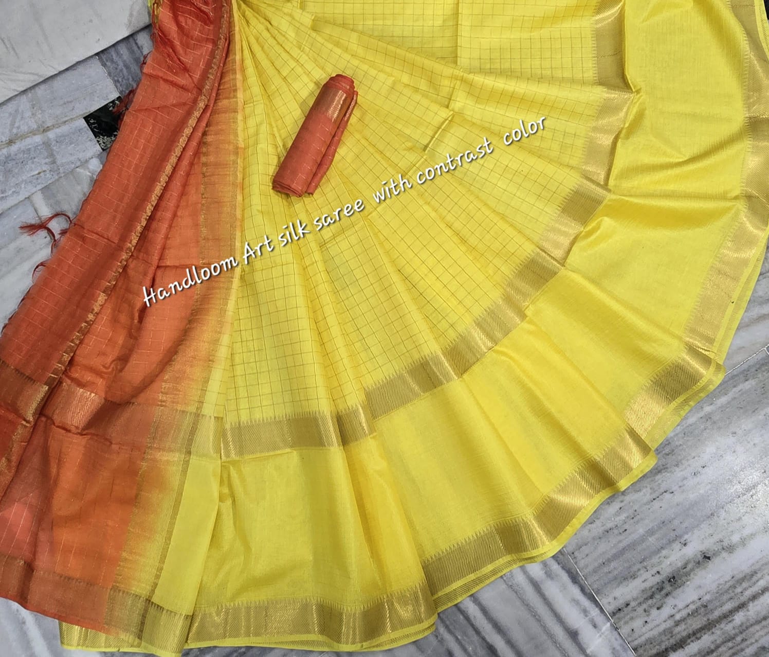 Yellow-orange dual-tone silk saree with golden border draped elegantly