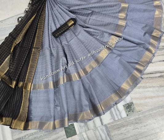 Gray-black dual-tone silk saree with golden border draped elegantly