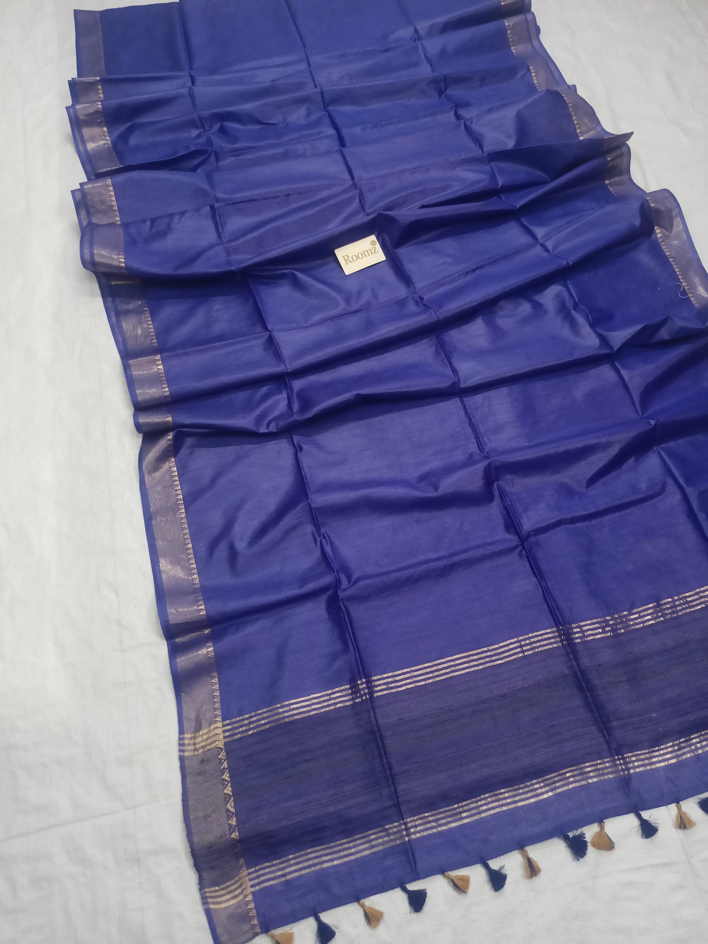 Close-up view of golden zari border on blue silk saree
