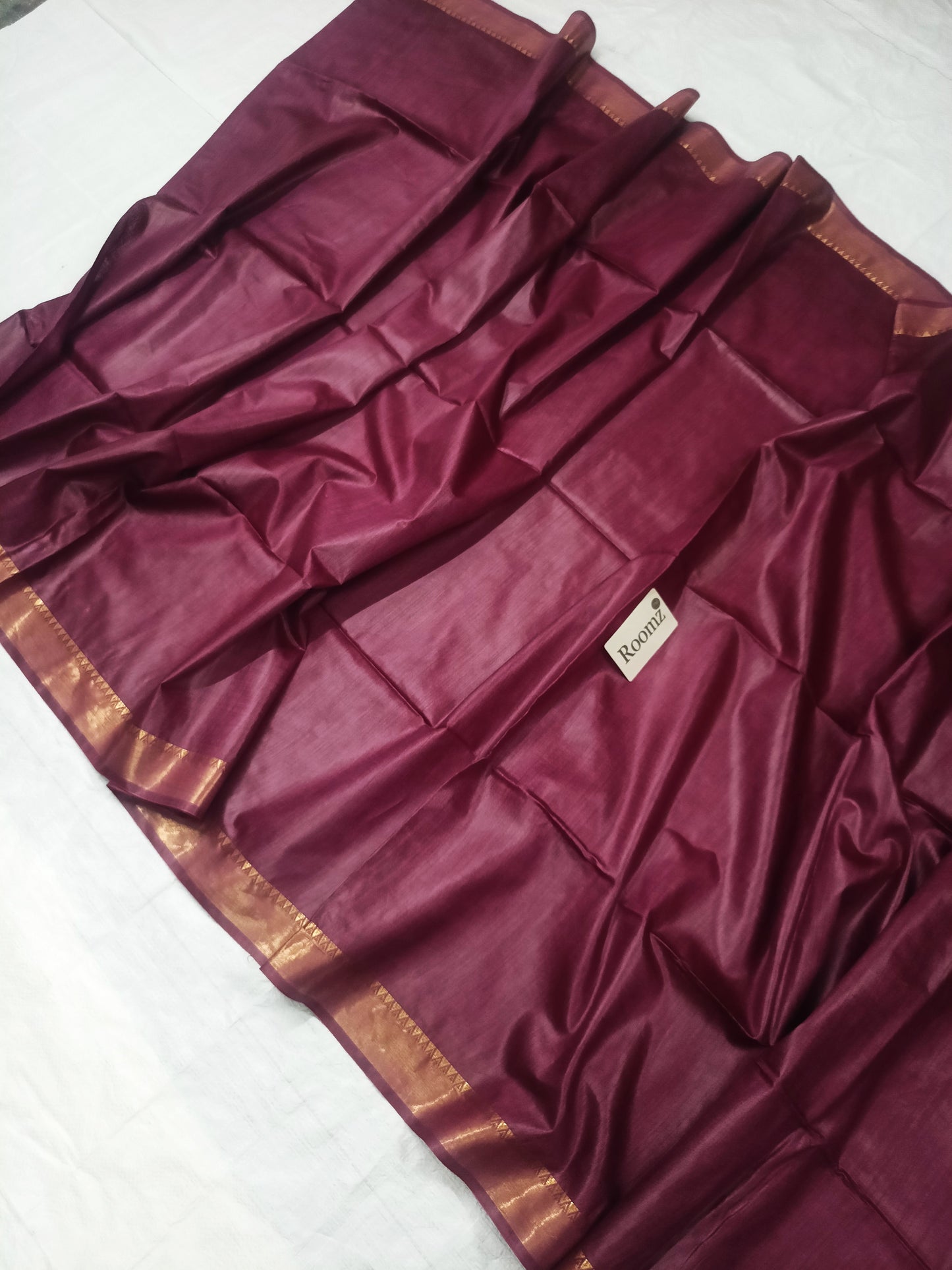 Close-up of the golden zari border on the brown silk saree